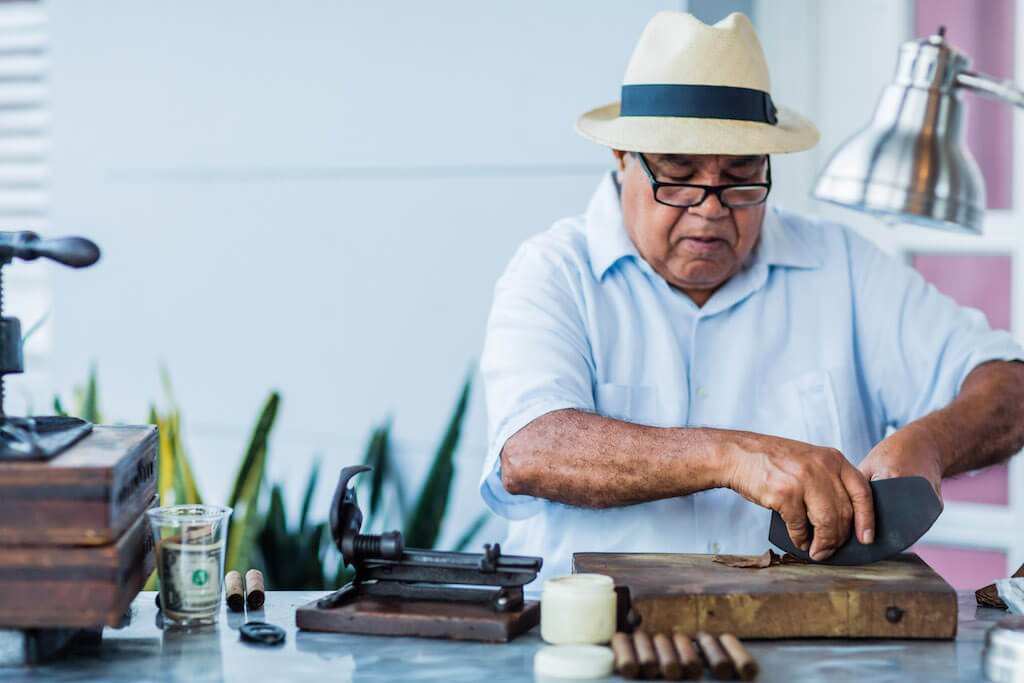 A cigar rollers demonstrates his art at an exclusive party.